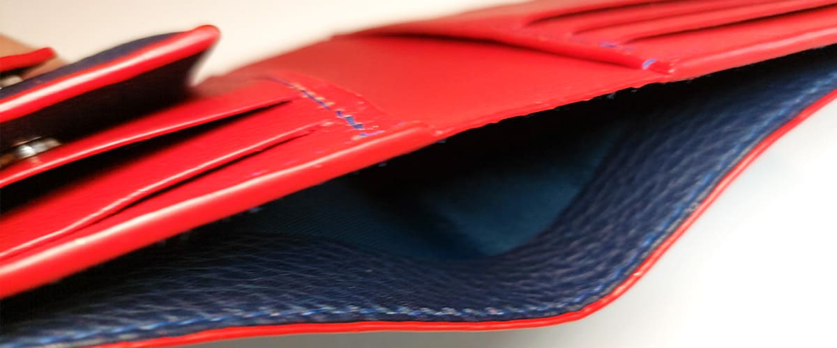 détails interieur portefeuille maio en cuir grainé bleu marin doublure cuir rouge